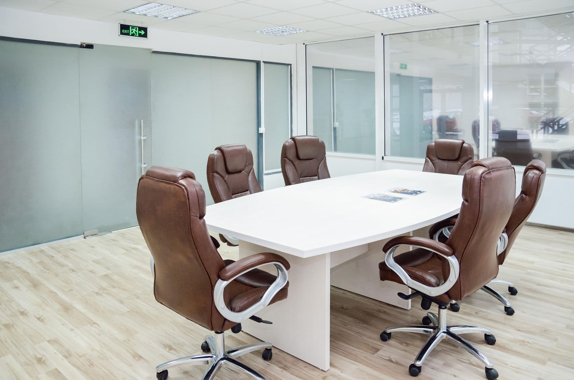 Meeting room with a white oval table and brown leather chairs